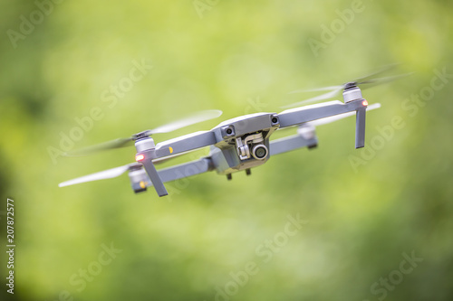 Close-up quadcopter drone with camera flying in park