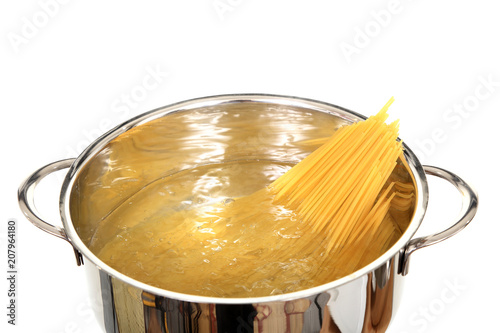 Gotowanie makaronu spagetti w błyszczącym metalowym garnku.