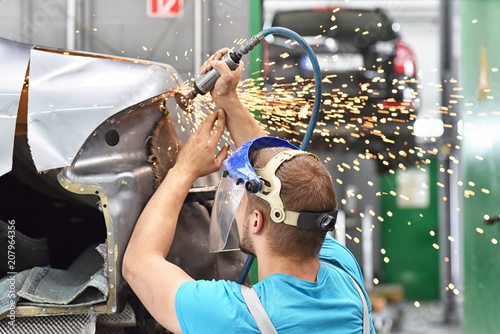 Karosseriebau - Mechaniker repariert Unfallschaden am Auto in einer Werkstatt // Body construction - mechanic repairs car accident damage in a workshop