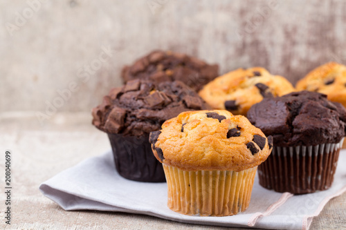 Homemade muffins with chocolate, vintage background.