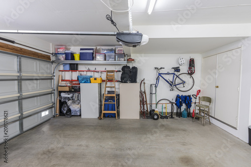 Organized clean suburban residential two car garage with tools, file cabinets and sports equipment. 
