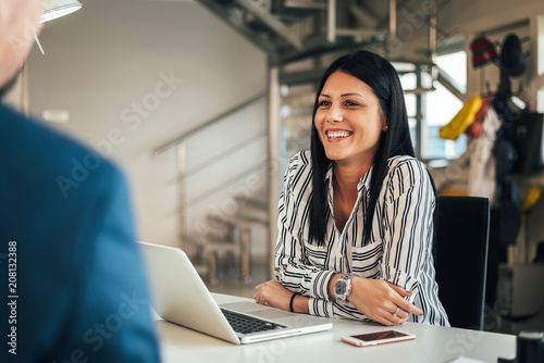 Young smiling saleswoman talking with a client.