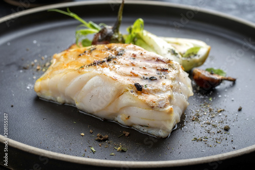 Modern Thai fried cod fish filet with bok choi and mushrooms as close up on a plate