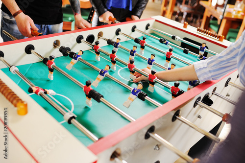 friends - guys and girls play table football.