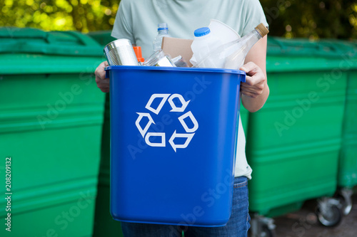 Close Up Of Woman Carrying Recycling Bin