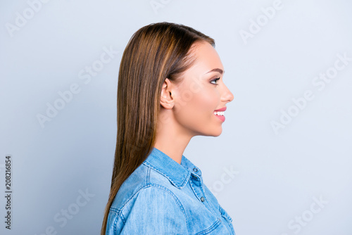 Profile half face portrait of pretty trendy woman in jeans shirt with cheerful expression isolated on grey background