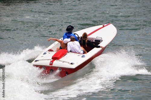 Sport high end runabout motorboat with four passengers aboard speeding across the Florida Intra-coastal Waterway off Miami Beach.