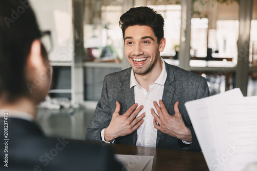 Business, career and placement concept - surprised caucasian man 30s rejoicing and showing at himself when hiring, during job interview with employees in office