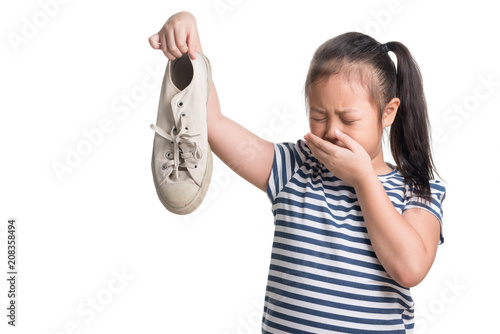 Asian kid girl age 7 year hold stinky shoe on white background