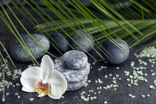 Spa stones and beautiful orchid flower on grey table