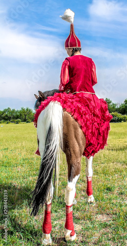 A girl in national Kazakh clothes on a horse