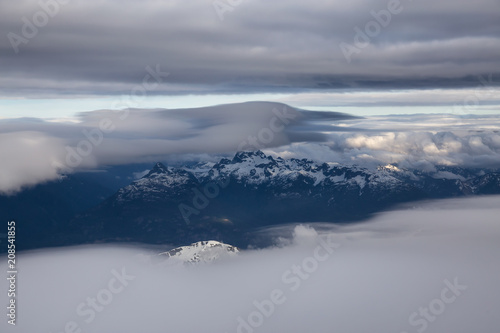 Aerial view of the striking Canadian Mountain Landscape covered in clouds. Taken North of Vancouver, British Columbia, Canada.