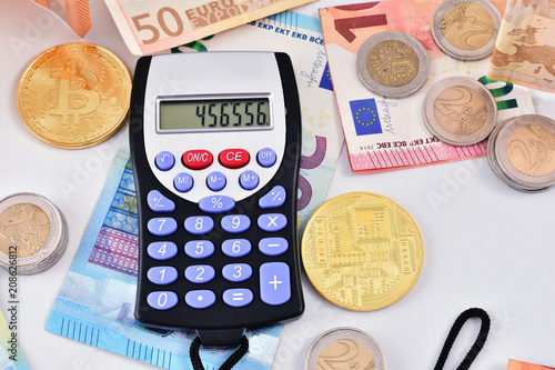 calculadora sobre dinero con billetes, monedas y dinero virtual