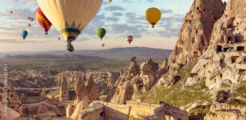 Balony nad tureckim parkiem narodowym w Göreme. Panorama Kapadocji - wielobarwne balony latające nad górską doliną starożytnego miasta jaskiniowego Uchisar.