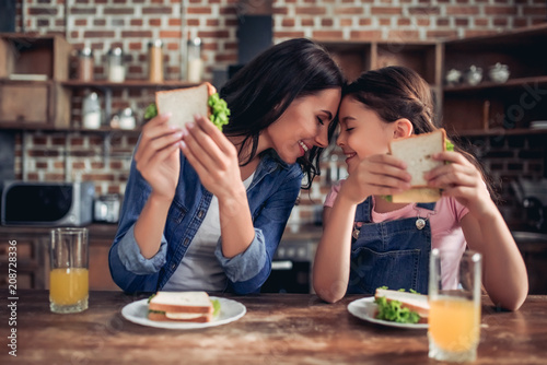 mother and daughter holding sandwiches