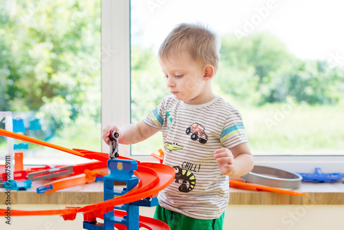 little boy playing with cars in the game center