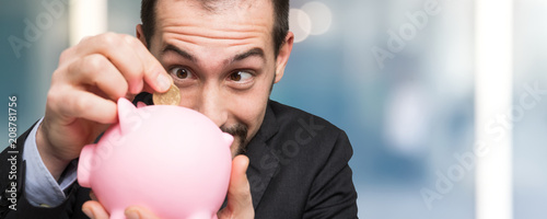 Businessman putting money in his piggy bank