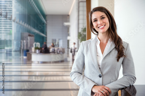 Smiling likable sincere and charming business woman financial executive type portrait inside commercial building