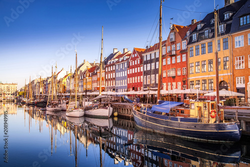 COPENHAGEN, DENMARK - MAY 6, 2018: picturesque view of historical buildings and moored boats reflected in calm water, copenhagen, denmark