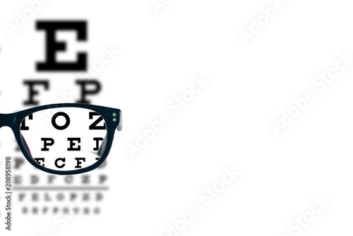 Eyeglasses with blurred optician visual text chart on a white background. Blank or empty space for your message