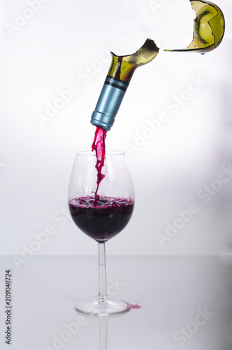 czerwone wino polane ze stłuczonej butelki