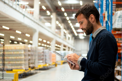 Manager holding digital tablet in warehouse