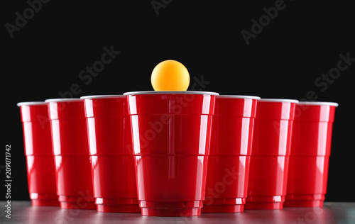 Cups and ball for beer pong on table