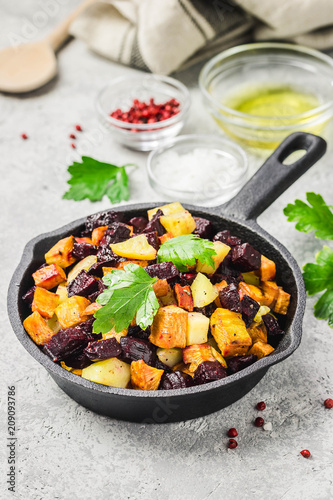 Balsamic roasted vegetables, carrots, sweet potato, pumpkin, beetroot, potato in cast iron skillet. Selective focus, space for text.