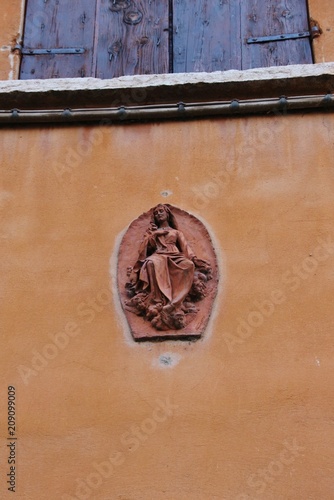 Stone sculpture of the blessed virgin Maria on the facade of Palazzo Ducale, Mantua. The Palazzo was the royal residence of the Gonzaga family. Built in the 14th to 17th century. Italy, South Europe.