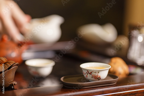 Tea ceremony. Master pours tea on white cups