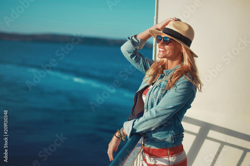 Young blonde woman traveler posing on cruise ship deck