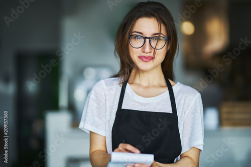 young waitress ready to take order on notepad in restauran