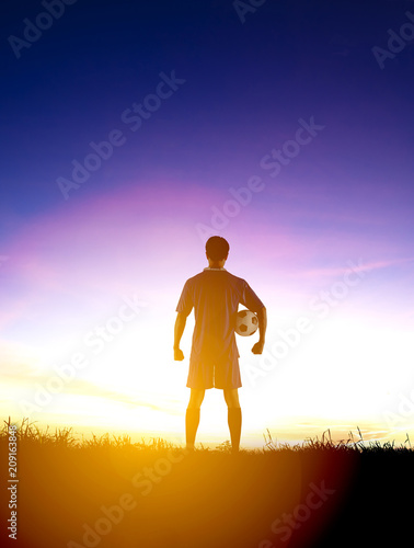 rear view soccer football player watching the sunrise