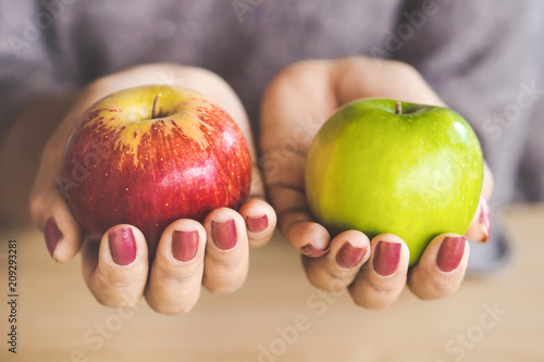 woman hand holding red and green apple fruit for diet 