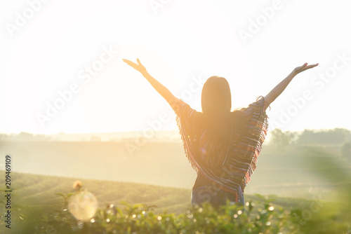 Lifestyle traveler women happy feeling good relax and freedom facing on the natural tea farm in the sunrise morning, Thailand. Travel Concept