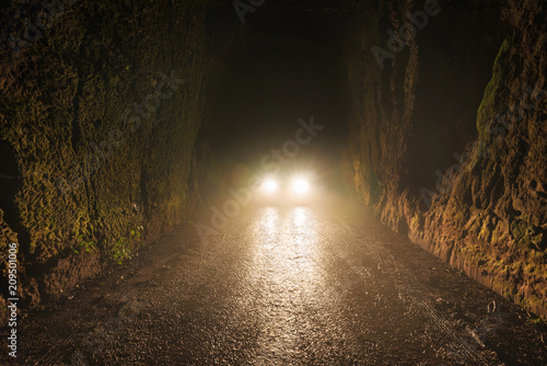 Car headlights at night in the foggy road