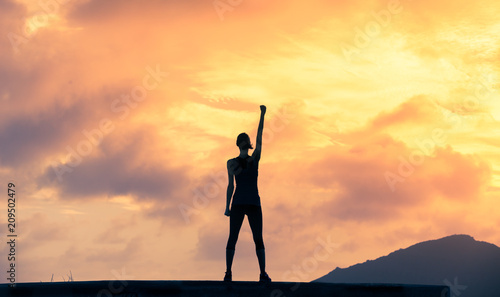 Stand strong. Woman with fist in the air. Feeling motivated, strength and courage concept. 