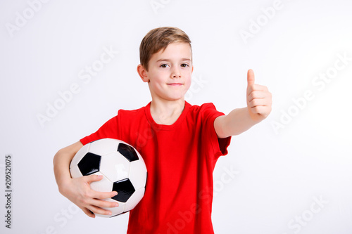 boy in red shirt with soccer ball and thumb up