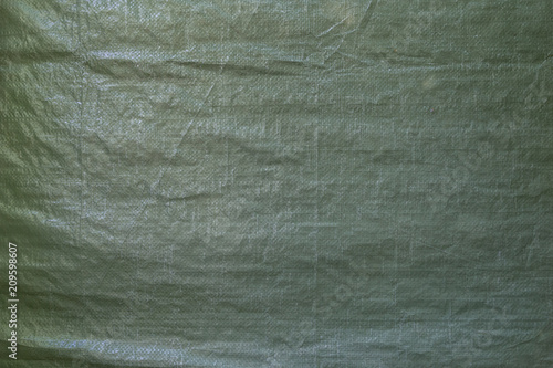 Full frame background of a wrinkled green tarp texture