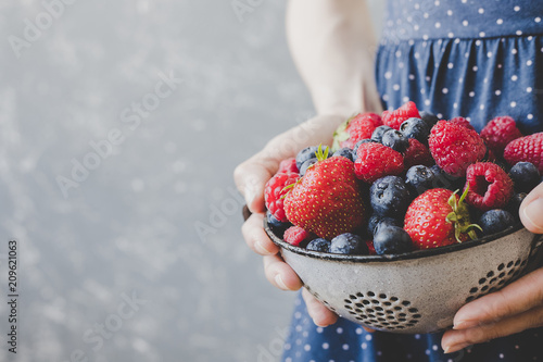 Hands holding fresh juicy berries. Summer background with copy space