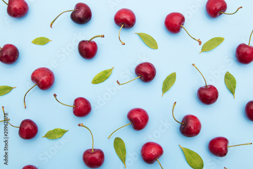 background of cherries and leaves on blue