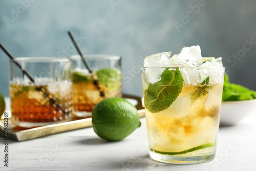 Glass of delicious mint julep cocktail on table