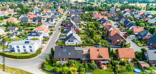 Typical German new housing development in the flat countryside of northern Germany between a forest and fields and meadows