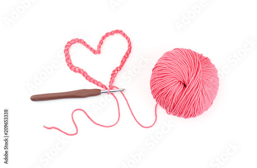 Ball of knitting yarn with crochet hook on white background