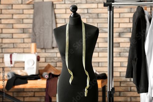 Tailor's mannequin with measuring tape in atelier