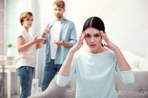 Strong headache. Unhappy depressed woman touching her temples while feeling depressed