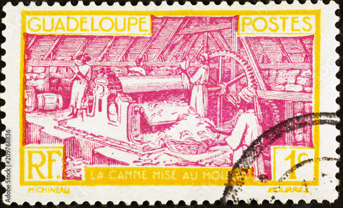 Processing of sugar cane on vintage postage stamp of Guadeloupe