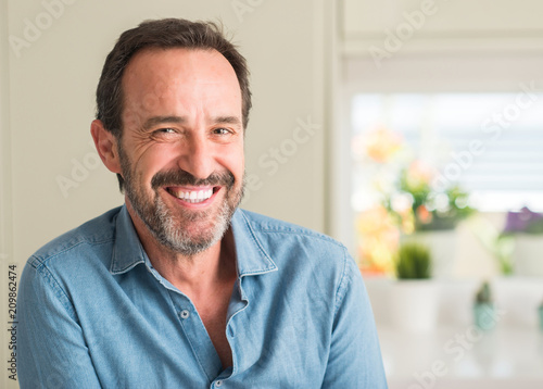 Handsome middle age man with a happy face standing and smiling with a confident smile showing teeth