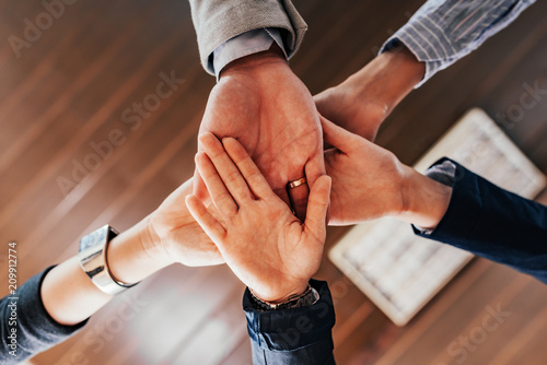 Bottom view of people hands holding together. Teamwork concept.