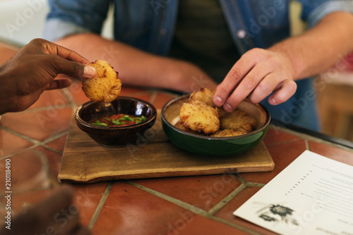 Two men sharing delicious food together at a bistro table